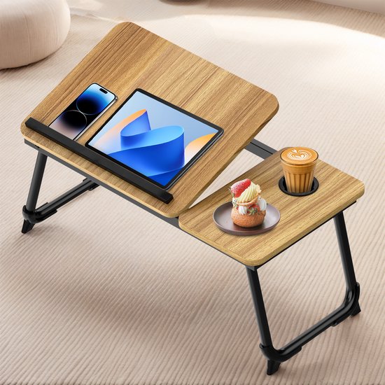 Houten laptoptafel met tablet, smartphone en een bordje met gebakje, plus een bekerhouder aan de zijkant.