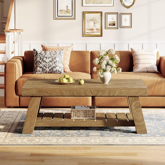 Bruine houten salontafel met een open opbergruimte aan de onderkant, in een woonkamer met bruine bank.