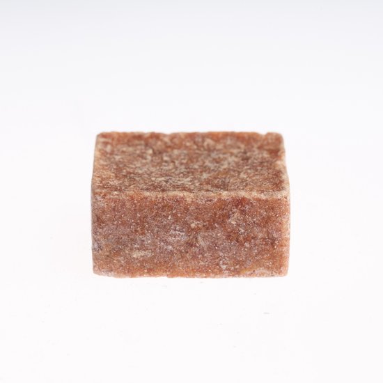 Een vierkant, bruin amberblokje met een korrelige textuur op een witte achtergrond.