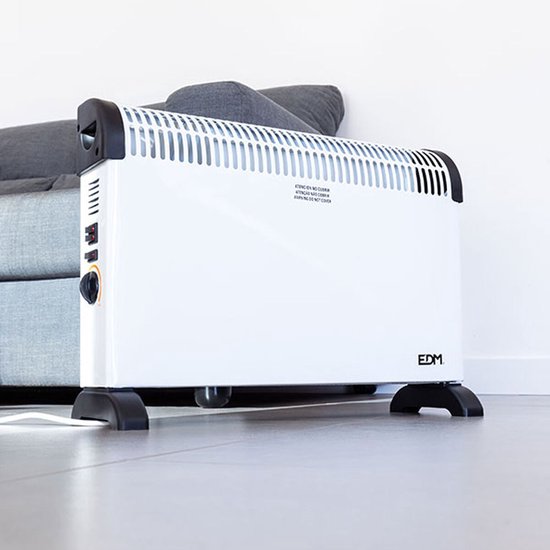 Witte convector met zwarte accenten en pootjes, naast een grijze bank. Zijkant met bedieningselementen.