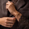 Gouden ring met roze steen en zirkonia's. Gouden armband met roze steentjes.