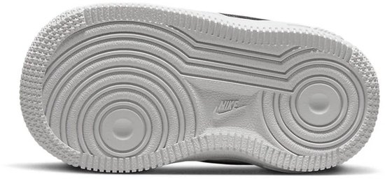Onderkant van een witte Nike Air Force 1 sneaker voor peuters, met het Nike-logo in het midden van de zool.