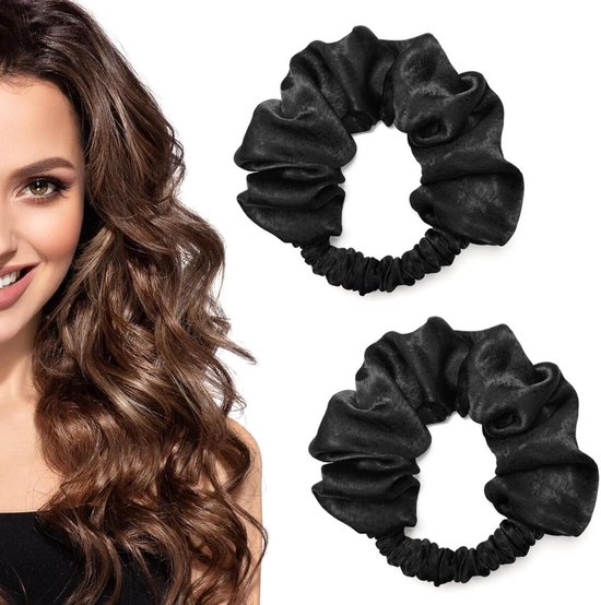 Twee zwarte, ruches scrunchies naast een deel van het gezicht van een vrouw met lang, golvend haar.