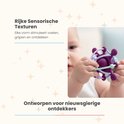 Baby met een paarse en groene balvormige bijtring met verschillende texturen.