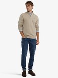 Man draagt beige trui met ritssluiting en spijkerbroek.