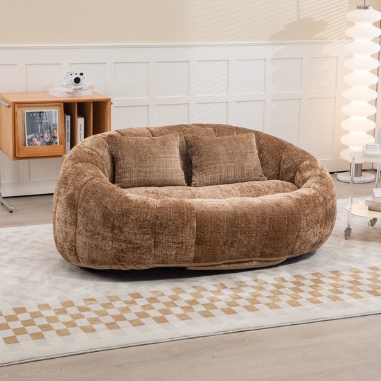 Koffiebruine chenille loungebank met verticale ribbels en twee kussens, in een woonkamer.