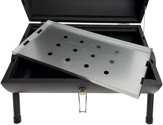 Zwarte draagbare BBQ opengeklapt, met een uitneembare metalen plaat met gaten, met zwarte pootjes.