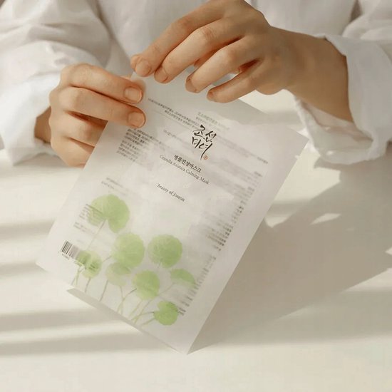 Een verpakking van een kalmerend gezichtsmasker van Beauty of Joseon met centella-asiatica. De verpakking toont groene bladeren.