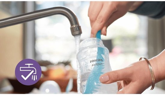 Mains lavant un biberon Philips Avent Natural Response sous le robinet.