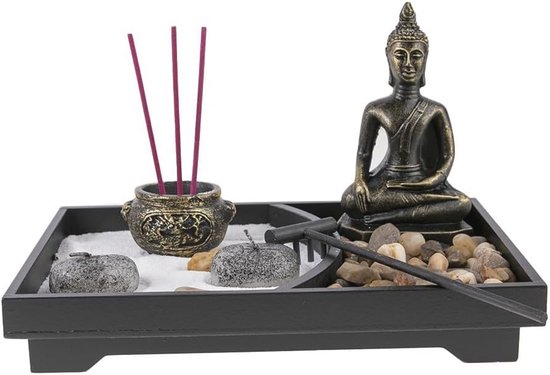 Zen tuin met Boeddhabeeld, wierookhouders met rode wierookstokjes, stenen en een harkje.