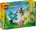 Set LEGO Creator 3-en-1 31384 représentant un colibri fait de briques LEGO vertes, roses et jaunes, buvant le nectar d'une fleur bleue.