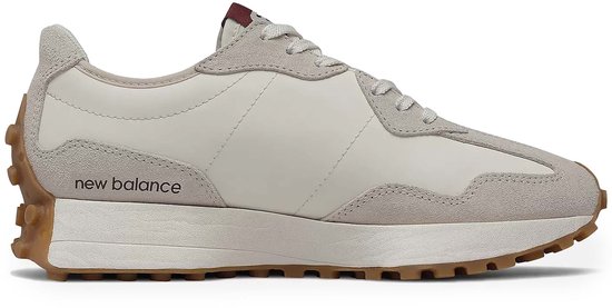 Witte New Balance sneaker met suède overlays in gebroken wit en bordeauxrode accenten. De zijkant toont 'new balance'.