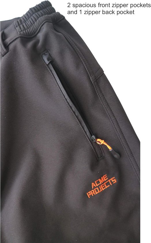 Zwarte softshell broek met oranje 'ACME PROJECTS' logo en een rits aan de zijkant.