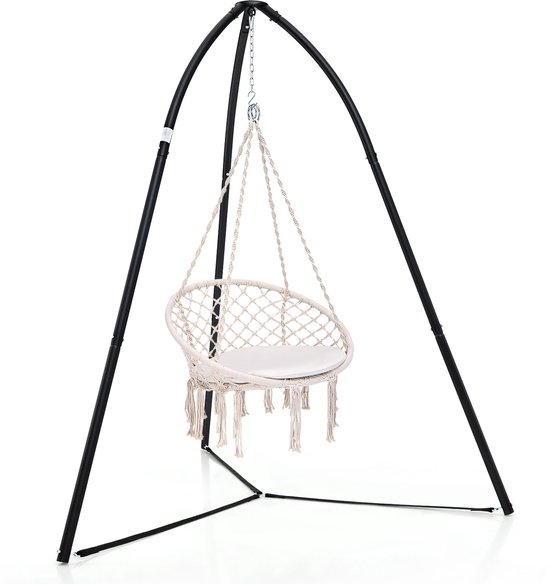 Zwart driepoot hangstoelframe met witte macramé hangstoel met franjes en een wit kussen.