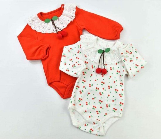 Deux bodies pour bébé : un blanc à imprimé cerises, un rouge, tous deux avec application de cerises et col en dentelle.