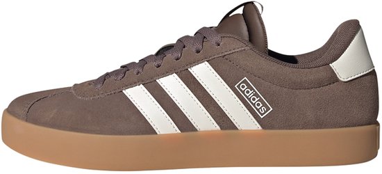 Bruine damessneakers met witte Adidas-strepen en een gum-kleurige zool.