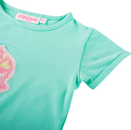 Detail van mintgroen T-shirt met opgerolde mouwen en pailletten.