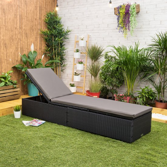 Zwarte ligstoel met grijze kussens in een tuin setting.