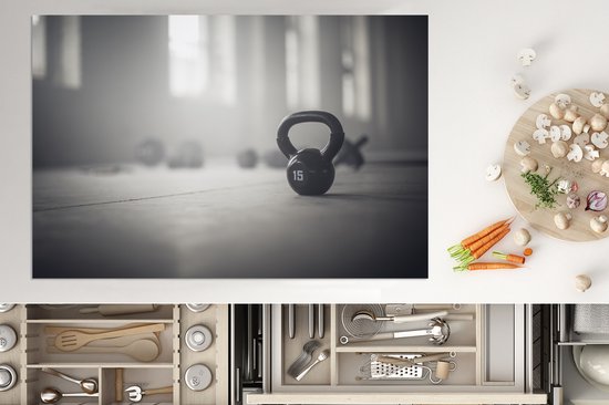 KitchenYeah® Inductie beschermer 76x51.5 cm - Verschillende kettlebellgewichten op de vloer in een fitnessruimte - Kookplaataccessoires - Afdekplaat voor kookplaat - Inductiebeschermer - Inductiemat - Inductieplaat mat