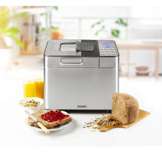 RVS broodmachine met brood, ontbijtgranen en sap op een keukentafel.