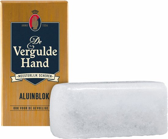Gouden verpakking met De Vergulde Hand Aluinblok en een wit aluinblok ernaast.
