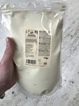 Een hand houdt een zak met 1 kg bio haverdrankpoeder van KoRo vast.