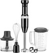 Zwarte KitchenAid staafmixer met accessoires: garde, hakmolen, mengbeker en panbeschermer.