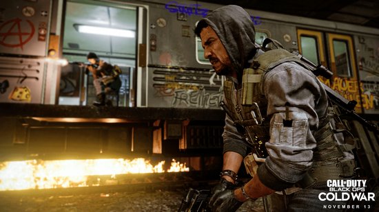 Man met capuchon en wapen, bij een trein met graffiti. 'Call of Duty: Black Ops Cold War'.