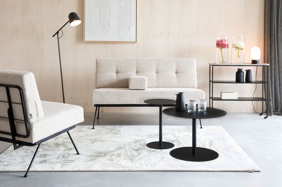 Zitje in beige bouclé stof en een bank staan in een modern ingerichte woonkamer.