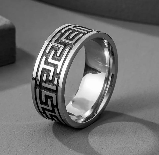 Zilverkleurige ring met een herhalend labyrint patroon aan de buitenzijde.