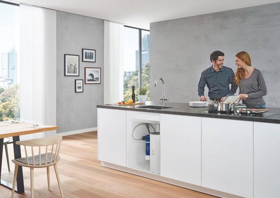 Een stel in een moderne keuken met een chroom GROHE kraan, met onderbouw filter en een koppel-kookplaat.
