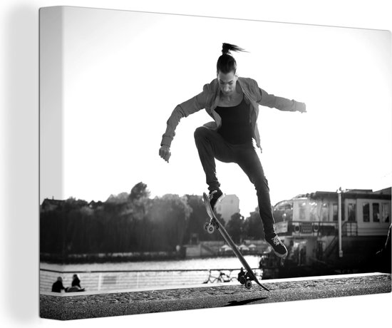 Canvas Schilderij Een vrouw doet een stunt met haar skateboard - zwart wit - 120x80 cm - Wanddecoratie