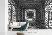 Behang - Fotobehang Onderaanzicht van de Eiffeltoren in Parijs - zwart wit - Breedte 600 cm x hoogte 400 cm