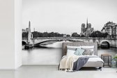 Behang - Fotobehang Oude brug over rivier de Seine in Parijs - zwart wit - Breedte 600 cm x hoogte 400 cm