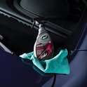 Bouteille de Turtle Wax Hybrid Solutions Ceramic 3-en-1 Detailer sur un chiffon vert dans une voiture.