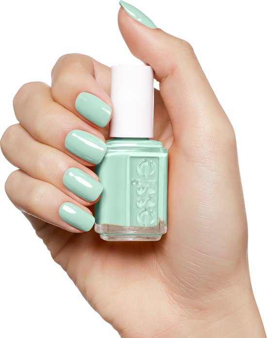 Hand met mintgroene Essie nagellak, houdt een flesje Essie nagellak vast.
