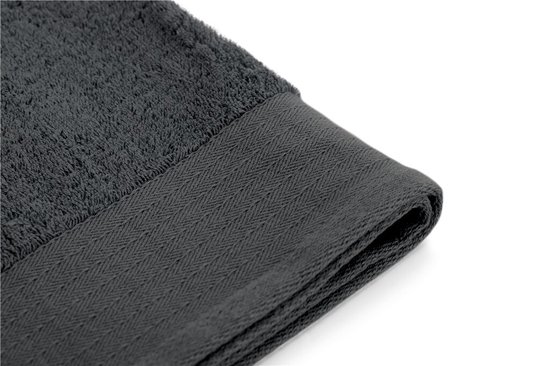 Detail van de verstevigde, visgraat-geweven rand van een antracietkleurige handdoek.