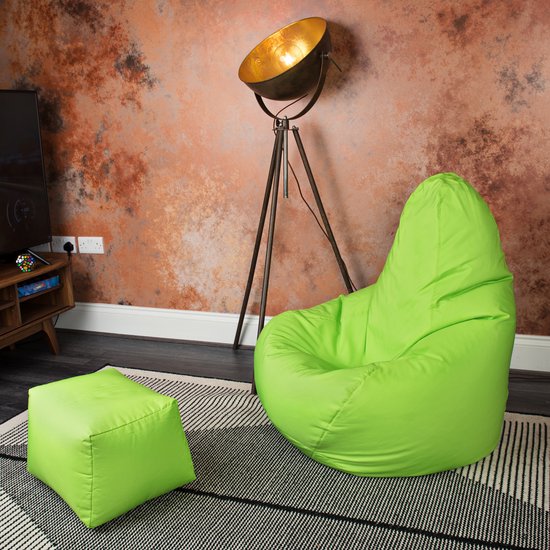 Lichtgroene zitzak en poef op een gestreept vloerkleed in een woonkamer.
