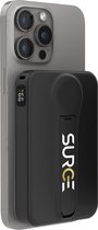 Zwarte Surge powerbank met ingebouwde standaard, magnetisch bevestigd aan de achterkant van een iPhone.