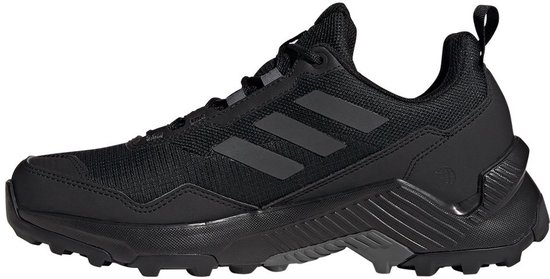 Een zwarte dames wandelschoen met zwarte Adidas-strepen en een robuuste zool.