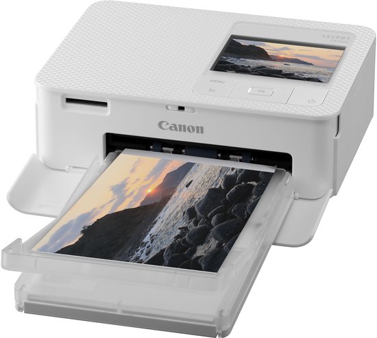 Witte Canon Selphy CP1500 mobiele fotoprinter die een foto van rotsen en een zonsondergang print.