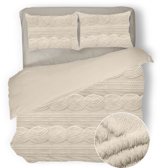 Couvre-lit couleur crème avec motif torsadé et oreillers assortis. Gros plan montrant la texture pelucheuse.