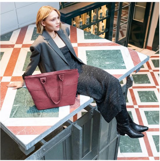 Dames zittend op tafel met bordeauxrode shopper met horizontale ribbels.