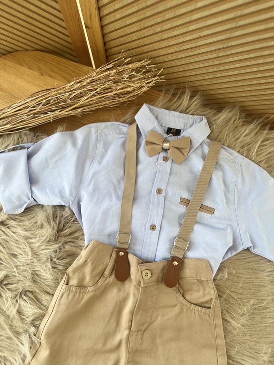 Lichtblauw overhemd met beige vlinderdas en bretels, gecombineerd met beige broek.