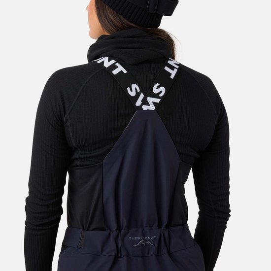 Achterkant van donkerblauwe skibroek met bretels met 'SWEDEMOUNT' tekst.
