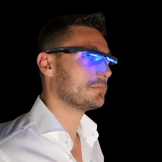 Man met wit overhemd draagt lichttherapiebril met blauw licht.