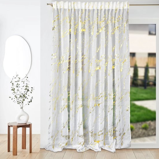 Een witte vitrage met gouden marmerprint hangt voor een raam.