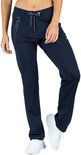 Vrouw in een donkerblauwe sportbroek met ritszakken en trekkoord, met witte sneakers.
