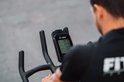 De console van de spinfiets toont de tijd (06:15), snelheid (27.0), afstand (27.4) en calorieën.