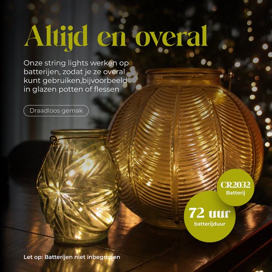 Twee gouden glazen decoraties, gevuld met warm witte lichtsnoeren, op een donkere houten tafel.